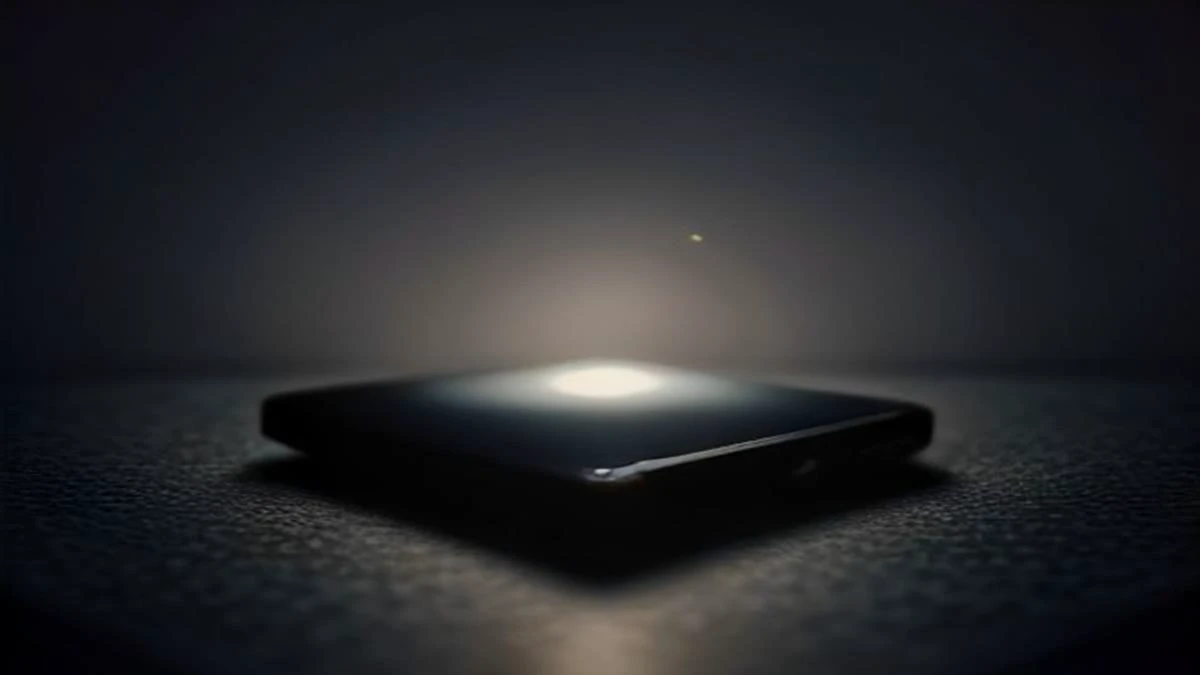A smartphone lying on a dark desk with a softly glowing abstract chat interface, the room behind it blurred into shallow focus